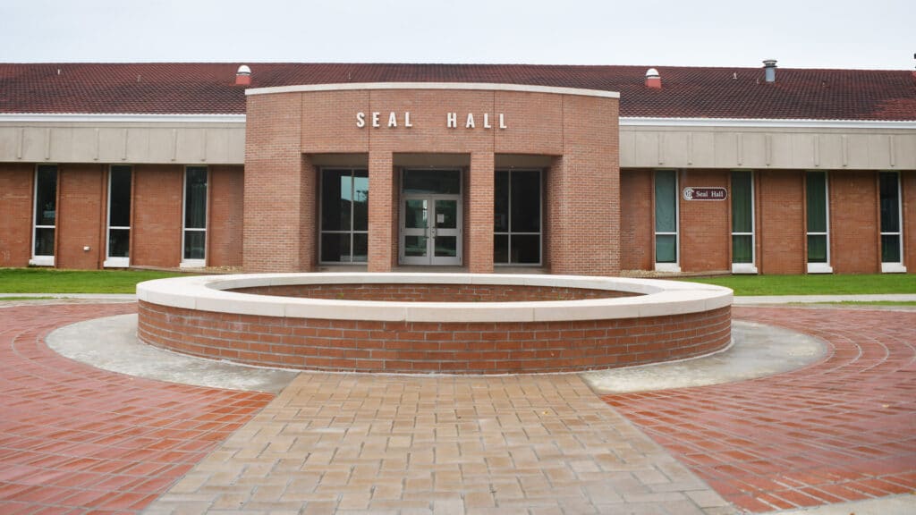 Exterior of Seal Hall main entrance with circular planter in front.