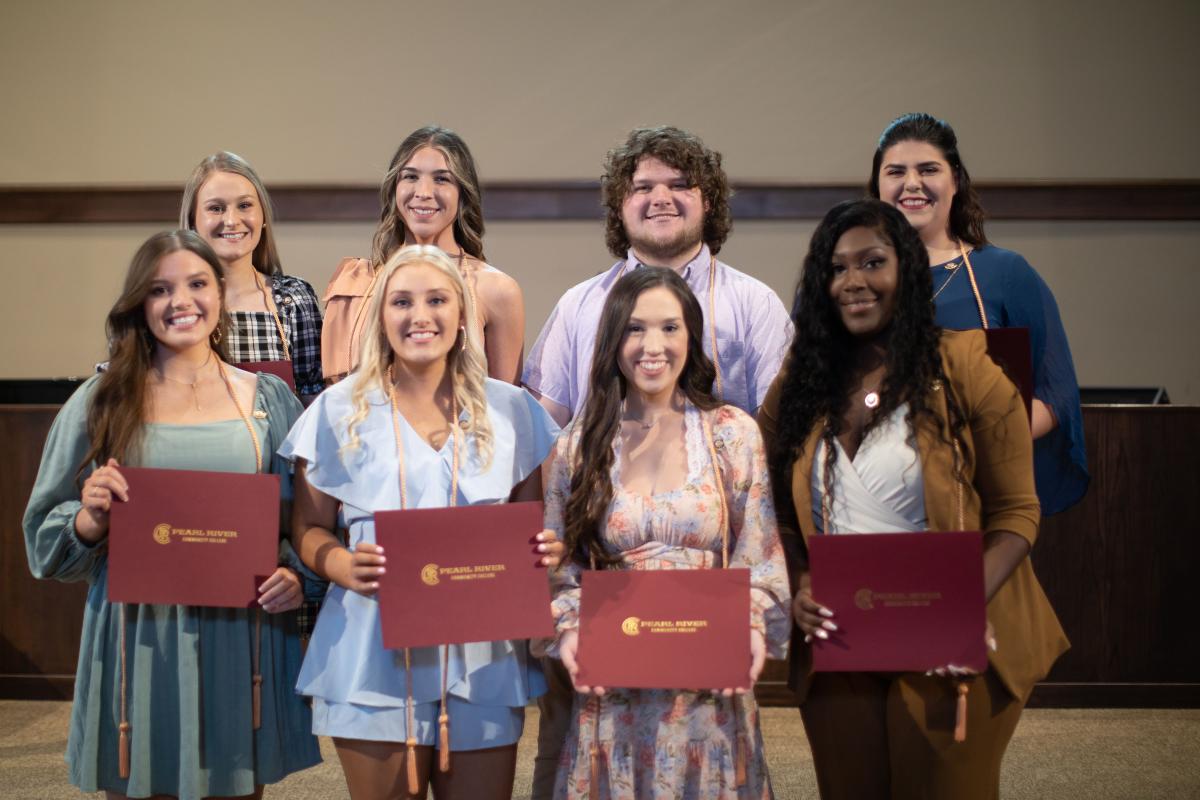 Seven women and one man stand on stage after Alpha Delta Nu Honor Society of Nursing Induction at PRCC May 2022