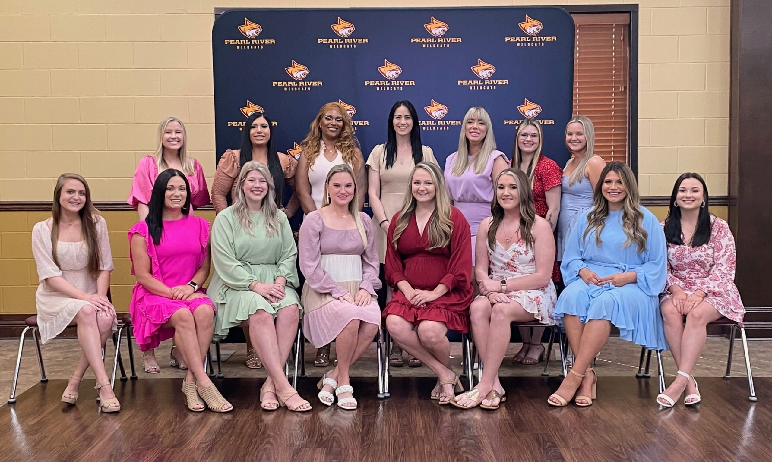 Dental Hygiene program graduates 2022 sit and stand in front of PRCC backdrop