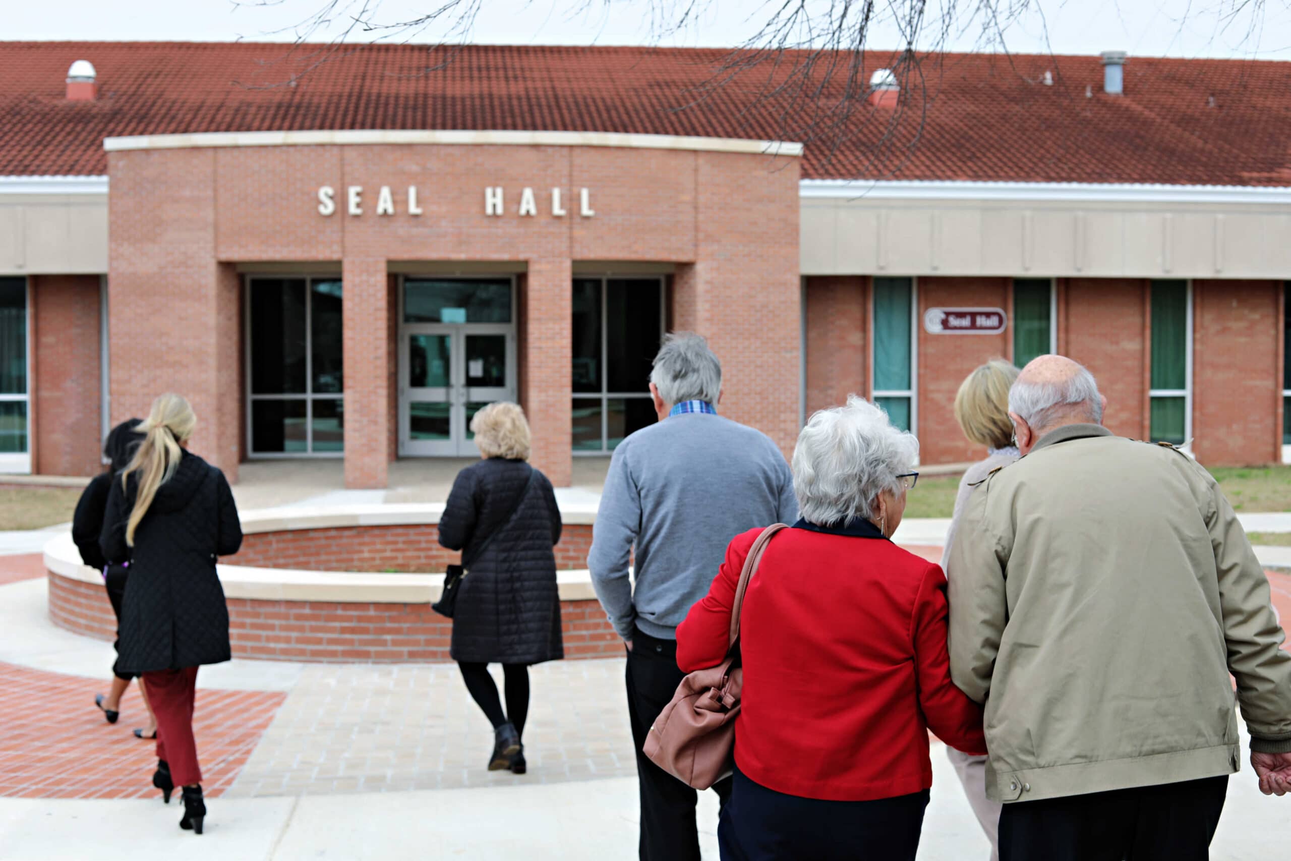 Group of donors walk towards the main entrance of Seal Hall on the PRCC Poplarville Campus