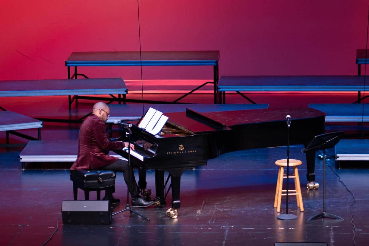 Dr Jeffrey Murdock plays piano on the stage of the Brownstone Center for the Arts atPRCC Feb 2022