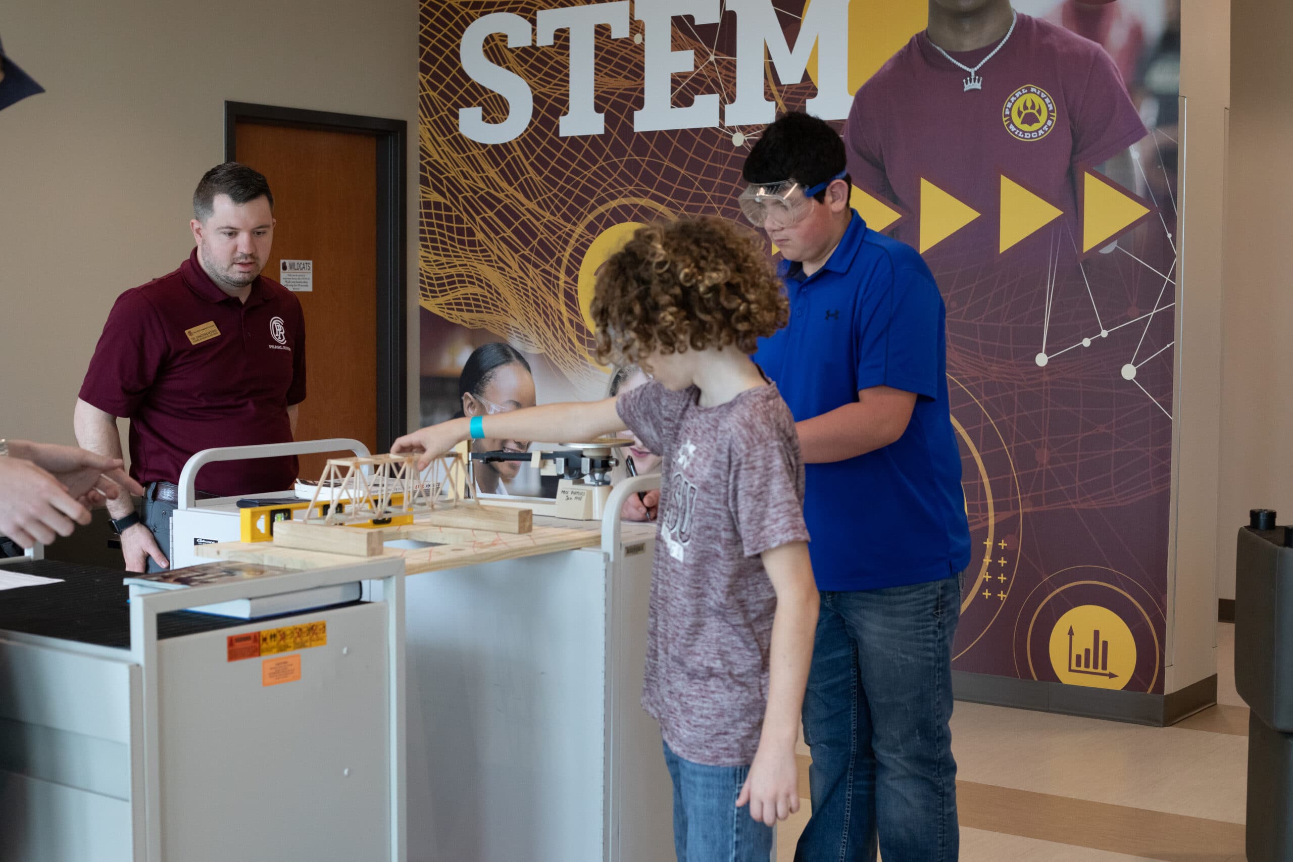 PRC Middle School students Griff Bowen and Carter Kirby set up their bridge while PRCC Math Instructor Jonathan Morris observes