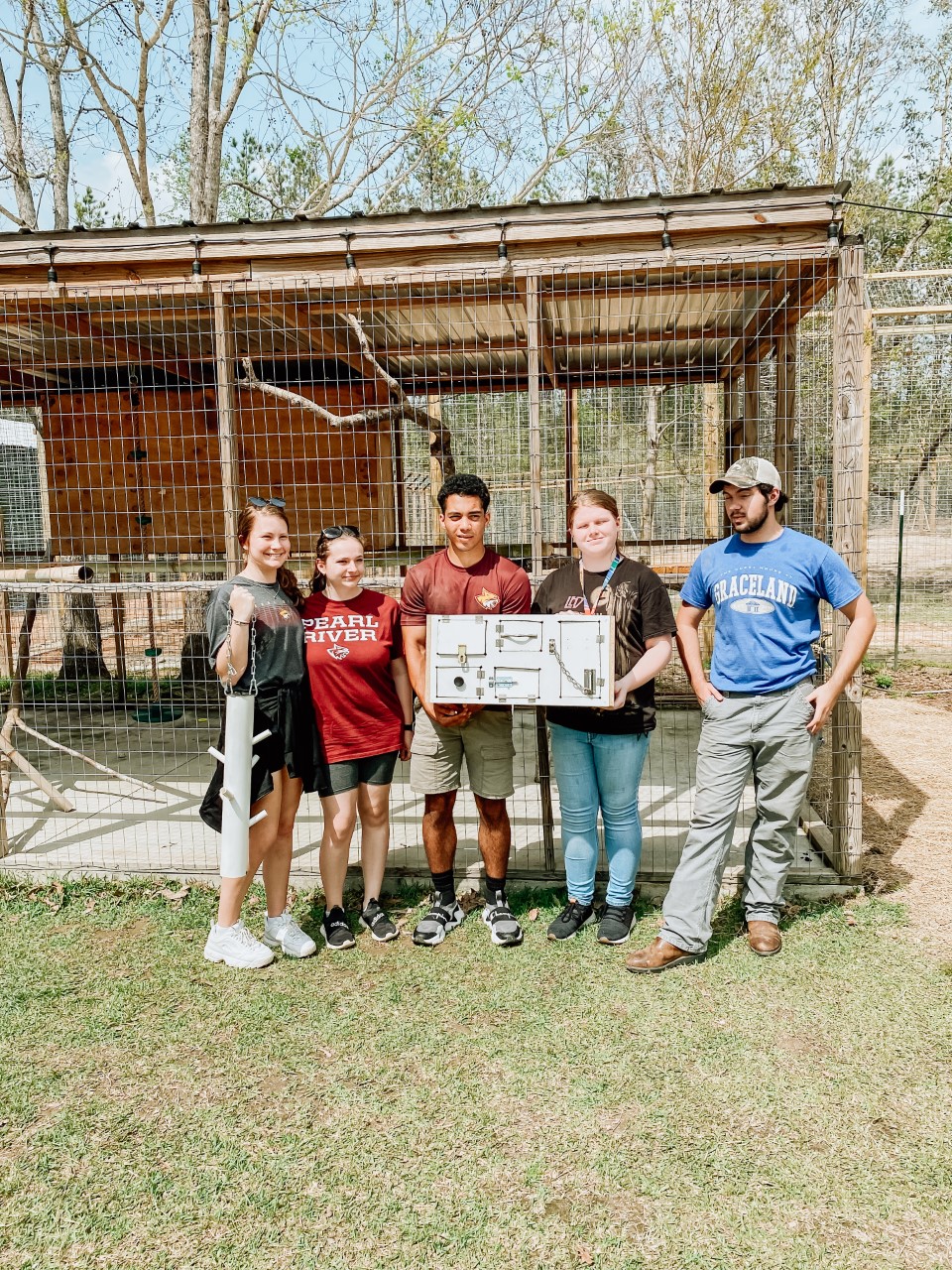 PRCC students hold finished puzzle for the capuchin monkey enclosure at Wild Acres