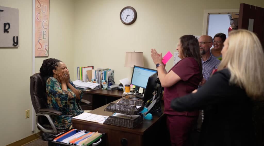 Latissa Dorsett is surprised at her desk by coworkers with the Outstanding PRCC Employee award for August 2022.