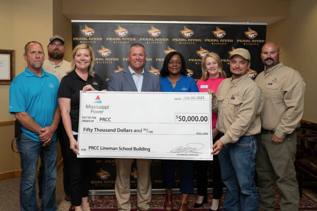Mississippi Power representatives stand with Dr. Adam Breerwood with a large check for $50,000 to support the Lineman Program.