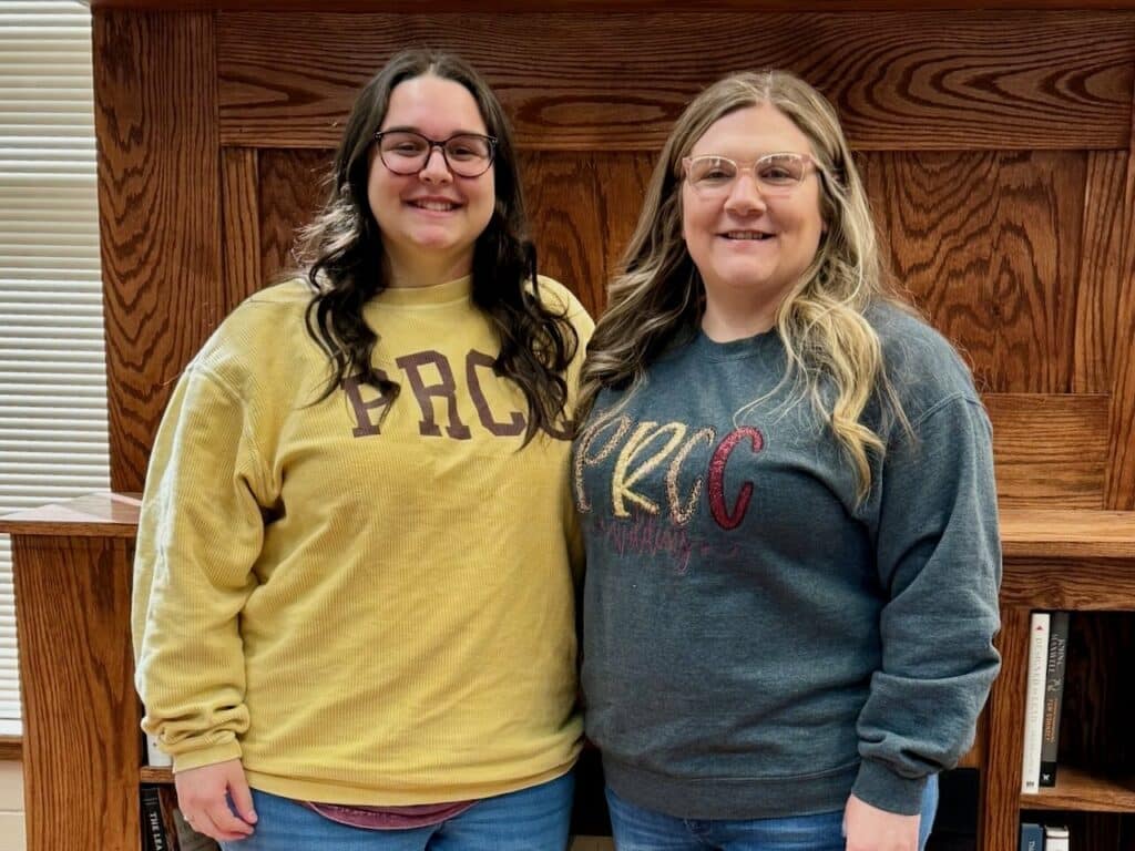 Mother and daughter stand next to each other while wearing PRCC sweatshirts.